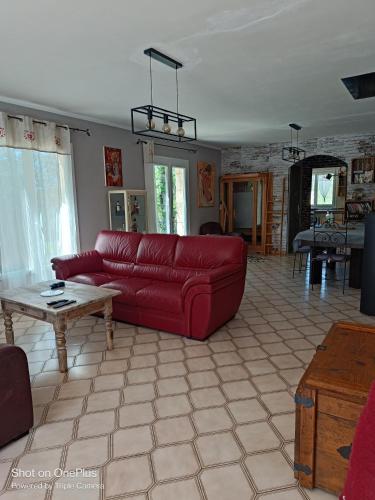 un salon avec un canapé rouge et une table dans l'établissement Villa privée, piscine chauffée, jacuzzi et sauna, à Saint-André-dʼOlérargues