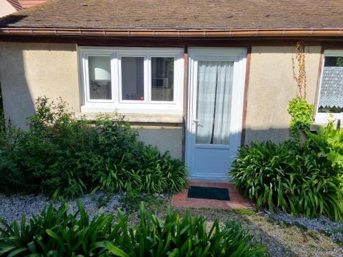 a house with a blue door and a window at Logement à 100m de la mer in Luc-sur-Mer