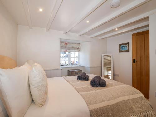 a bedroom with a large bed with two pillows on it at Harbour View in Looe