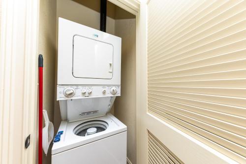 a washer and dryer in a bathroom with a door at 30A Luxury Suite with King Bed, Parking, Pool & Balcony in Santa Rosa Beach