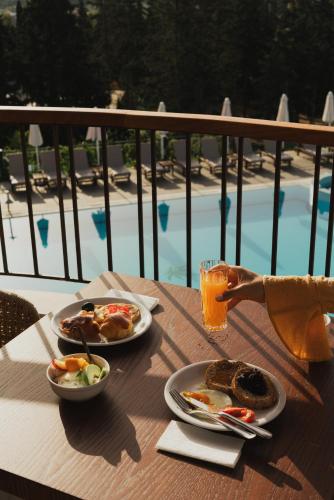 a table with two plates of food and a glass of orange juice at Gerakas Belvedere hotel in Vasilikos