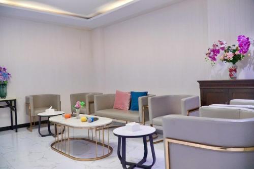 a waiting room with couches and tables and flowers at D Eco Wellness Center in North Pattaya
