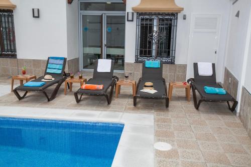 a group of chairs next to a swimming pool at Hostal Boutique Bajamar in Nerja