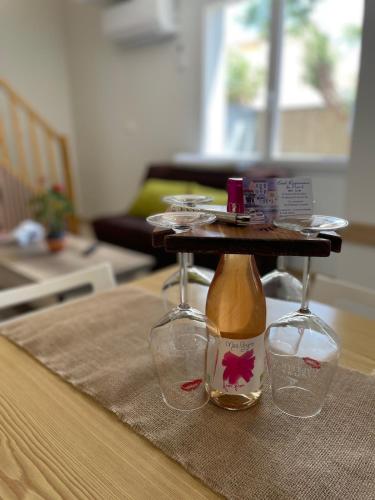 une table avec deux verres à vin et un plateau de service dans l'établissement L'Écho des Vagues T3 Beach, à Port-la-Nouvelle