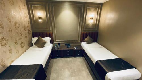 two beds in a small room at Gulf Hotel Mumbai- The Boutique Hotel Colaba Mumbai in Mumbai