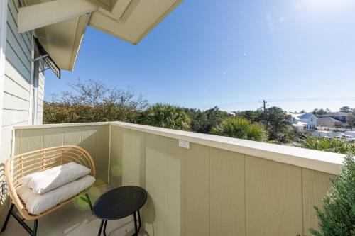 a balcony with a rattan chair and a table at 30A Luxury Suite with King Bed, Parking, Pool & Balcony in Santa Rosa Beach
