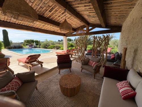 une terrasse avec des canapés et une piscine dans l'établissement La maison des Amis, à Maillane