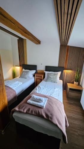 two beds in a hotel room with a towel on the bed at Hiša stare mame in Kamnik