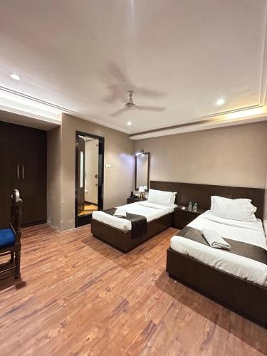 a hotel room with two beds and a mirror at Gulf Hotel Mumbai- The Boutique Hotel Colaba Mumbai in Mumbai
