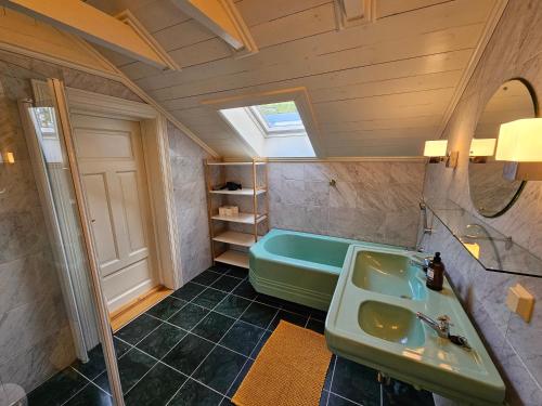 a bathroom with a green sink and a tub at Sigurd's Loft in Vossevangen