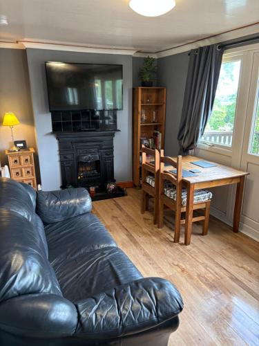 a living room with a couch and a table and a fireplace at Glangwna Holiday Park in Caernarfon