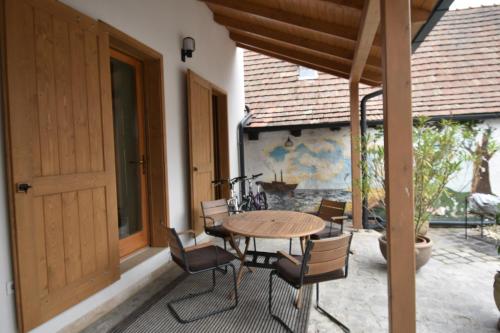 a patio with a wooden table and chairs on a porch at Gőzhajó Loft - Családi ház terasszal, 2 fürdőszobával, kerékpárral in Szentendre