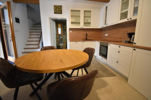 a kitchen with a wooden table and chairs at Gőzhajó Loft - Családi ház terasszal, 2 fürdőszobával, kerékpárral in Szentendre