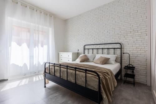 une chambre avec un lit et un mur de briques dans l'établissement Speakeasy, à Lido di Ostia