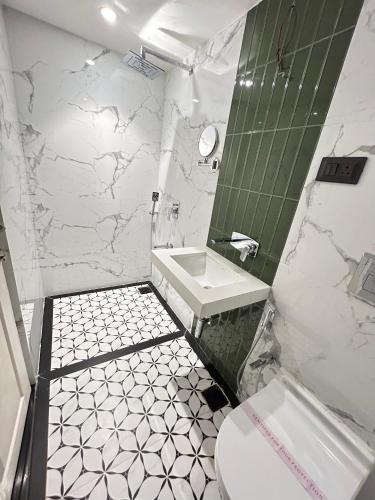 a bathroom with a sink and a toilet at Gulf Hotel Mumbai- The Boutique Hotel Colaba Mumbai in Mumbai