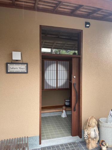 a door to a building with a teddy bear sitting outside at Sakura house in Kyoto