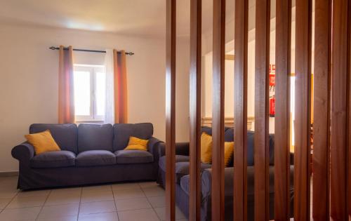 a living room with a blue couch and a window at Fonte da Rosa Guest House APT1 in Belmonte