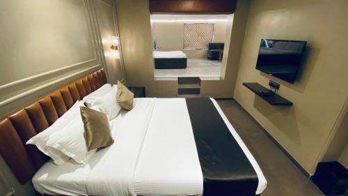 a large bed in a room with a mirror at Gulf Hotel Mumbai- The Boutique Hotel Colaba Mumbai in Mumbai