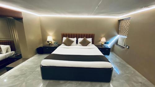 a bedroom with a large bed with two night stands at Gulf Hotel Mumbai- The Boutique Hotel Colaba Mumbai in Mumbai