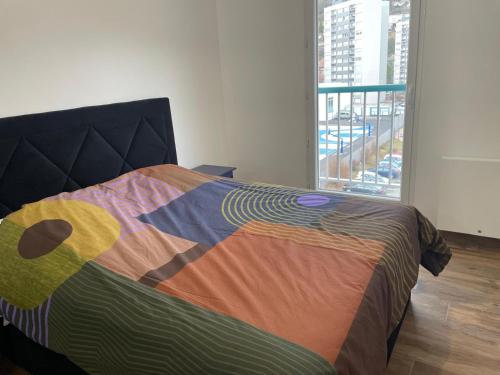 une chambre avec un lit coloré avec une fenêtre dans l'établissement Confort et moderne Genève Paris, à Bellegarde-sur-Valserine