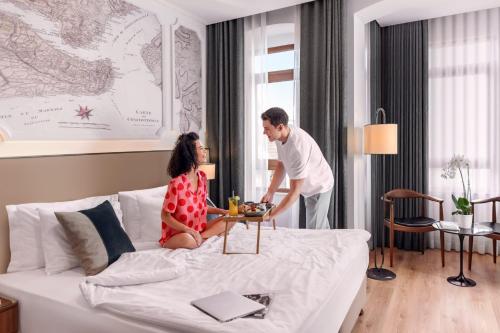 a man and woman sitting on a bed in a hotel room at Akka Suites Taksim-Special Class in Istanbul