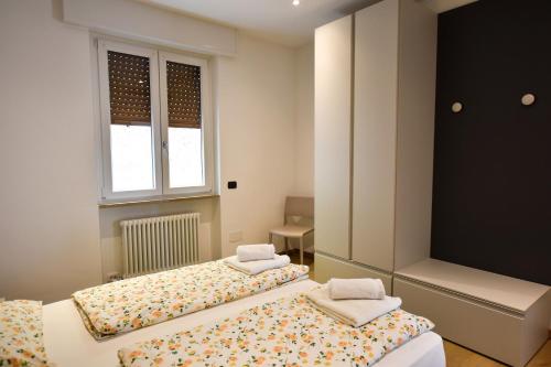 two twin beds in a room with a window at Casa Manu in Brenzone sul Garda