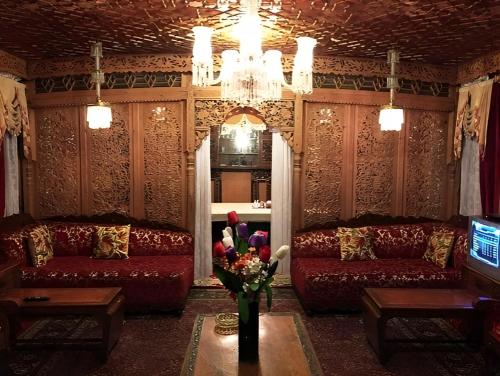 a living room with two couches and a vase of flowers at The Heritage Amina Group Of Houseboats in Srinagar