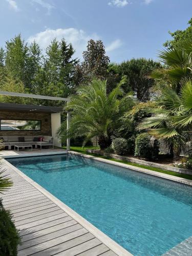 - une piscine dans une cour avec une terrasse en bois dans l'établissement Apartment Cap Ostrea, à Andernos-les-Bains