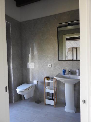 a bathroom with a sink and a toilet and a mirror at Donna Maria Ludovica in Pescia Romana