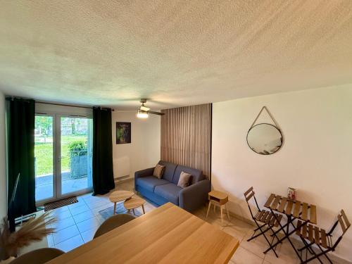 un salon avec un canapé bleu et une table dans l'établissement Lum'Arles, à Arles