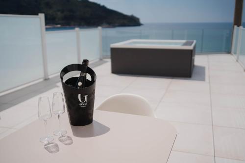 a bottle of wine in a cup on a table with two glasses at Hotel Ficocella in Palinuro