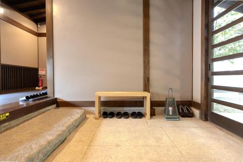 a room with a bench and a table on the floor at 逸仙居 Japanese Style House in Fuefuki
