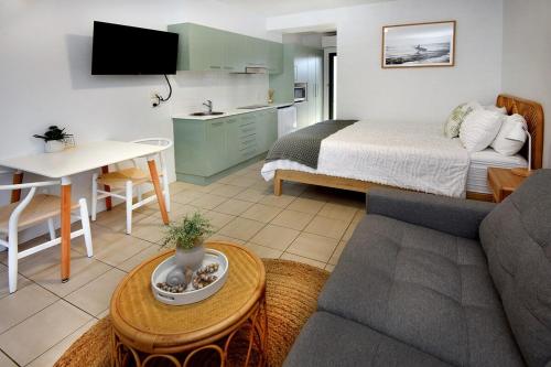 a living room with a bed and a couch at Murrays Beach Studio Sawtell in Sawtell