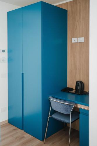 a blue desk with a chair in a room at Hotel Ficocella in Palinuro