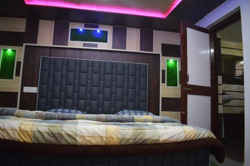a bedroom with a large bed with a black headboard at Green valley homestay in Khajjiar 