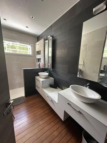 une salle de bain avec deux lavabos et un grand miroir dans l'établissement Villa familiale à 20 mn de Lyon, à Fleurieux-sur-lʼArbresle