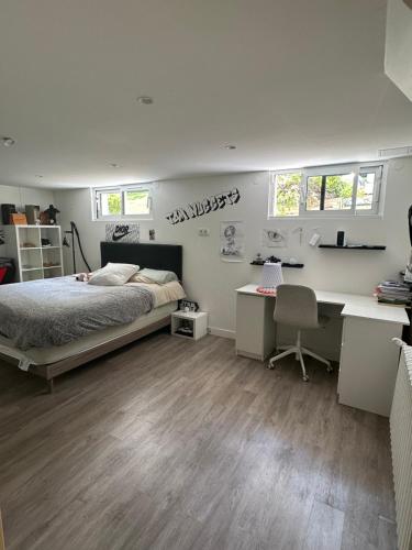 une chambre avec un lit et un bureau dans l'établissement Villa familiale à 20 mn de Lyon, à Fleurieux-sur-lʼArbresle
