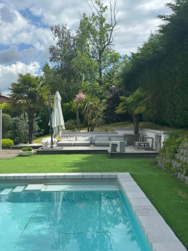 - une piscine dans une cour avec une pelouse dans l'établissement Villa familiale à 20 mn de Lyon, à Fleurieux-sur-lʼArbresle