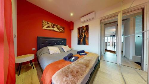 une chambre avec un lit avec un mur orange dans l'établissement Le Melrose Port Nature 5 Village Naturiste Cap d'Agde, au Cap d'Agde