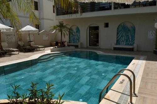 a large swimming pool with blue water in a building at IDEE SUİTES Fethiye in Fethiye