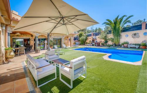 a patio with an umbrella and chairs and a pool at Pet Friendly Home In Segur De Calafell in Segur de Calafell