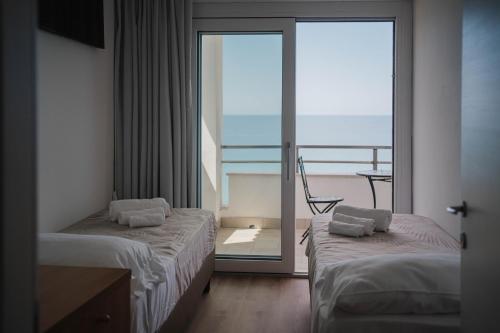 a hotel room with two beds and a balcony at Hotel Ficocella in Palinuro