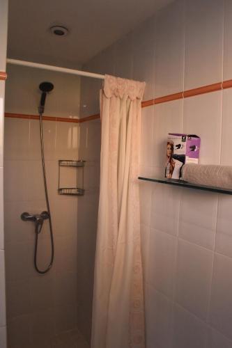 una ducha en un baño con cortina de ducha en Apartamentos Les Palmeres, en Platja d'Aro