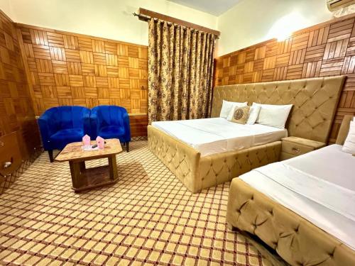 a hotel room with two beds and a table and chairs at Sweet Villa Guest house Islamabad G9-4 in Islamabad