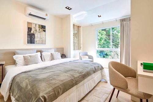 a bedroom with a large bed and a window at SAAY WELCOME CNX Pool Villa in Chiang Mai