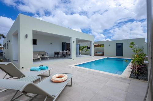 een villa met een zwembad en een patio bij Villa Kura Cura - 5 Minutes From Mambo Beach in Willemstad