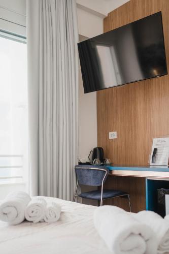 a hotel room with a bed and a desk with a television at Hotel Ficocella in Palinuro