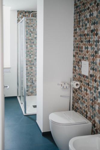 a white bathroom with a toilet and a sink at Hotel Ficocella in Palinuro