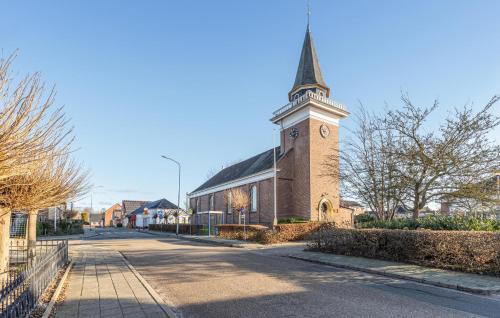 a church with a clock tower on a street at Stunning Home In Wagenborgen With Wifi in Wagenborgen