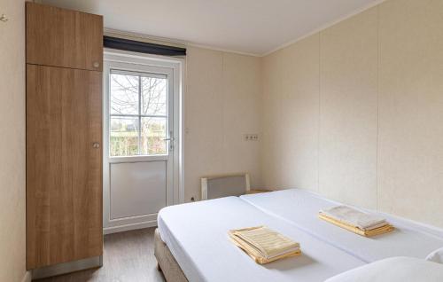 a bedroom with a white bed and a window at Stunning Home In Wagenborgen With Wifi in Wagenborgen